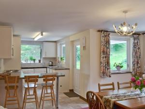 a kitchen and dining room with a table and chairs at Bellegrove Cottage in Watermillock
