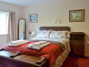 a bedroom with a bed with two towels on it at Bellegrove Cottage in Watermillock