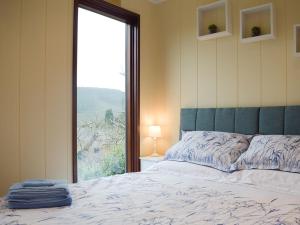 a bedroom with a bed and a large window at The Wooden Lodge in Aymestrey