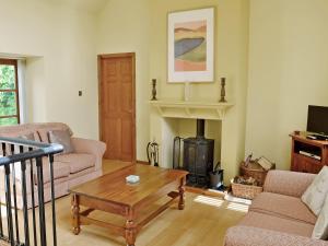 a living room with a coffee table and a fireplace at The Old Sunday School in Dalbeattie