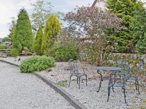 two chairs and a table in a garden at The Old Sunday School in Dalbeattie