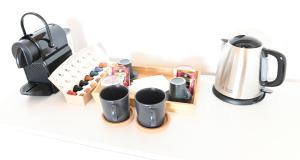 a group of cups and a coffee maker on a counter at Bull House in SantʼAgata Bolognese