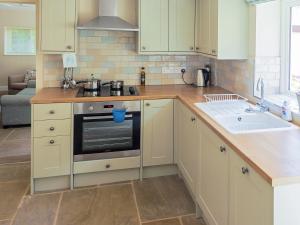 a kitchen with white cabinets and a stove top oven at Stone Lodge in Fulbeck