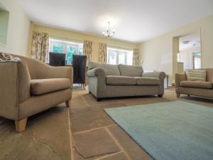 a living room with couches and chairs and a rug at Stone Lodge in Fulbeck