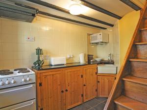 a kitchen with wooden cabinets and a stove at Sherrifs Lodge - Hw7730 in Myddfai