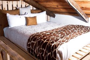 a large bed in a room with wooden ceilings at Rustic Luxury Farm Cabin located in Hwedza - 2031 