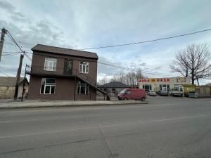 a brown building on the side of a street at Hotel Elit in Ninotsminda