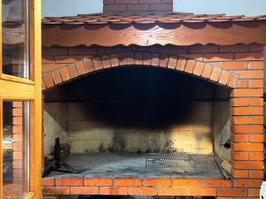 a brick fireplace with a bench in it at Barbara in Otočac