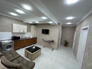 een woonkamer met een bank en een keuken bij Hotel Elit in Ninotsminda