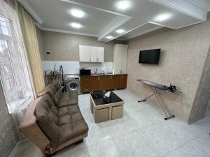 Hotel Elit في Ninotsminda: غرفة معيشة فيها أريكة وتلفزيون