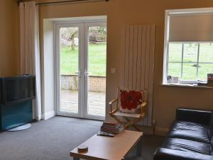 a living room with a couch and a sliding glass door at The Old Pumphouse in Thropton