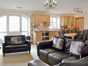 a living room with a couch and a kitchen at 4 Pengraig Draw in Llanychaiarn