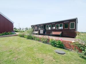 a train car parked next to a yard with a bench at Railway Carriage One - E5337 in Wetheringsett