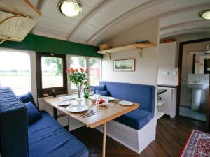 a dining room with a table and blue chairs at Railway Carriage One - E5337 in Wetheringsett