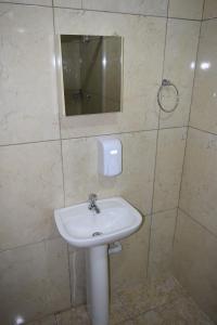 uma casa de banho com um lavatório branco e um espelho. em Hospedagens São Borja RS em São Borja