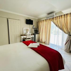 a bedroom with a large bed with a red blanket at Nine On Borghorst in Port Elizabeth