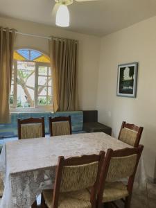 uma sala de jantar com uma mesa e cadeiras e uma janela em Residencial Sombreiro em Florianópolis