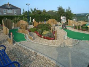 a miniature park with a golf course and a blue bench at Meadow Lakes 56 in Chapel Saint Leonards