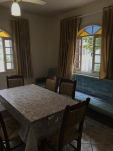 comedor con mesa, sillas y ventanas en Residencial Sombreiro en Florianópolis