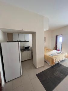 a room with a refrigerator and a bed in it at DERC Temporarios in Río Cuarto