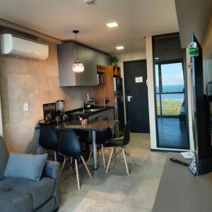 a kitchen and living room with a table and a couch at Apartamento no 20º andar Barra Home Stay in Recife