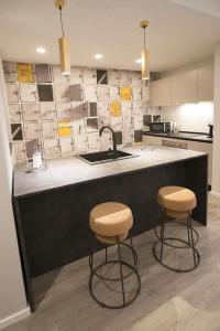 a kitchen with two bar stools and a sink at Blessed Vatican Home in Rome