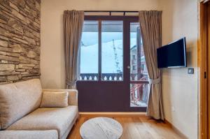 - un salon avec un canapé et une fenêtre dans l'établissement Appartement 123 (RDP), à Tignes