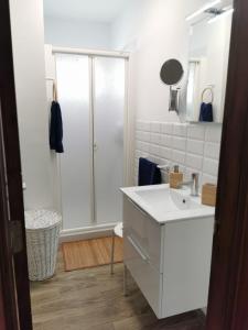 a white bathroom with a shower and a sink at The Blue House in Las Lagunas