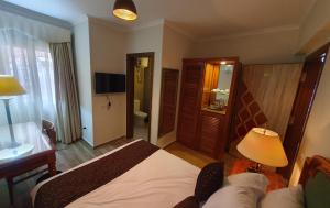 a bedroom with a bed and a desk and a bathroom at Kemet Boutique Hotel in Cairo