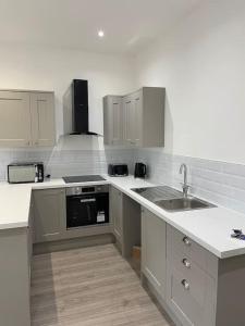 a kitchen with a sink and a stove top oven at Starry Night 2 Bed Apartment in Birkenhead