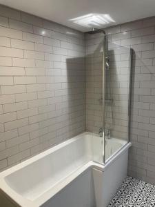 a white bathroom with a tub and a shower at Starry Night 2 Bed Apartment in Birkenhead