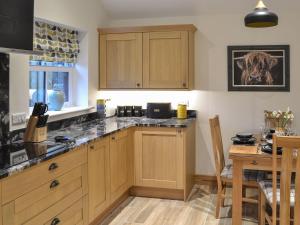 cocina con armarios de madera y mesa de comedor en Chancer, en Newlyn