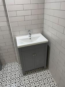 a bathroom with a sink and a tiled floor at Starry Night 2 Bed Apartment in Birkenhead