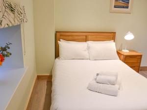 a bedroom with a large white bed with a chair at Chancer in Newlyn