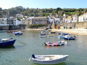 un grupo de barcos en el agua cerca de una ciudad en Chancer, en Newlyn