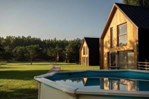 a house with a swimming pool in front of a house at Osada Hygge in Gostynin