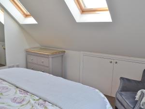 a bedroom with skylights and a bed and a chair at Coastal Retreat in Felpham
