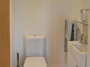 a bathroom with a white toilet and a sink at Coastal Retreat in Felpham