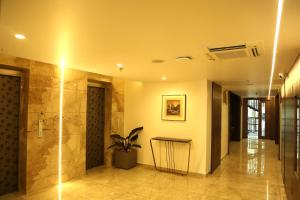a hallway with a shower and a plant in a building at Crystal Suites in Badagara