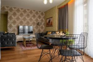 - un salon avec une table, des chaises et une télévision dans l'établissement My Palace Rooms Hotel SAW, à Istanbul