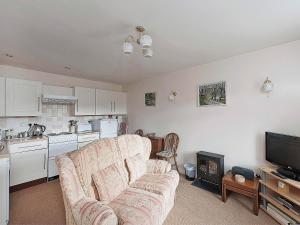 a living room with a couch and a kitchen at Pear Tree Farm Cottages - Rchm38 in Ebberston