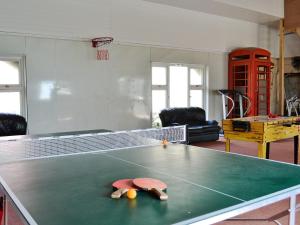 a ping pong table with two balls on top of it at Glanmwrg Barn in Trostre