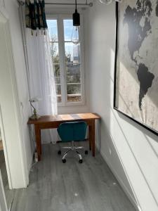 een bureau en een stoel in een kamer met een raam bij L'Industriel in Sens