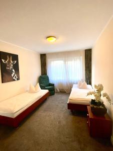 Pokój hotelowy z 2 łóżkami i zielonym krzesłem w obiekcie Monteurwohnung w mieście Emstek