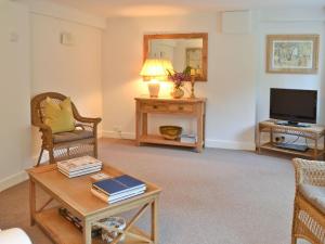 a living room with a coffee table and a tv at The Cottage in Stroud