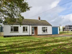 a small white house with a blue garage at Little Blagdon Bungalow in North Tamerton