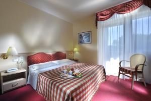 a hotel room with a bed with a tray of food on it at Hotel Arizona in Lignano Sabbiadoro