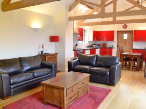 a living room with two leather couches and a table at Haddocks Nook in Aldwark