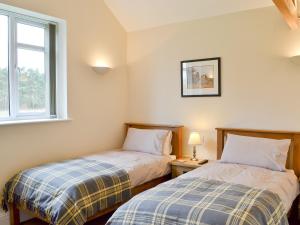 2 camas en una habitación pequeña con ventana en Haddocks Nook, en Aldwark