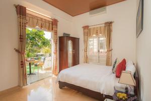 um quarto com uma cama e uma porta para um pátio em Strawberry Garden Homestay em Hoi An
